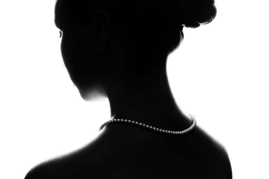 Silueta de mujer con collar de perlas